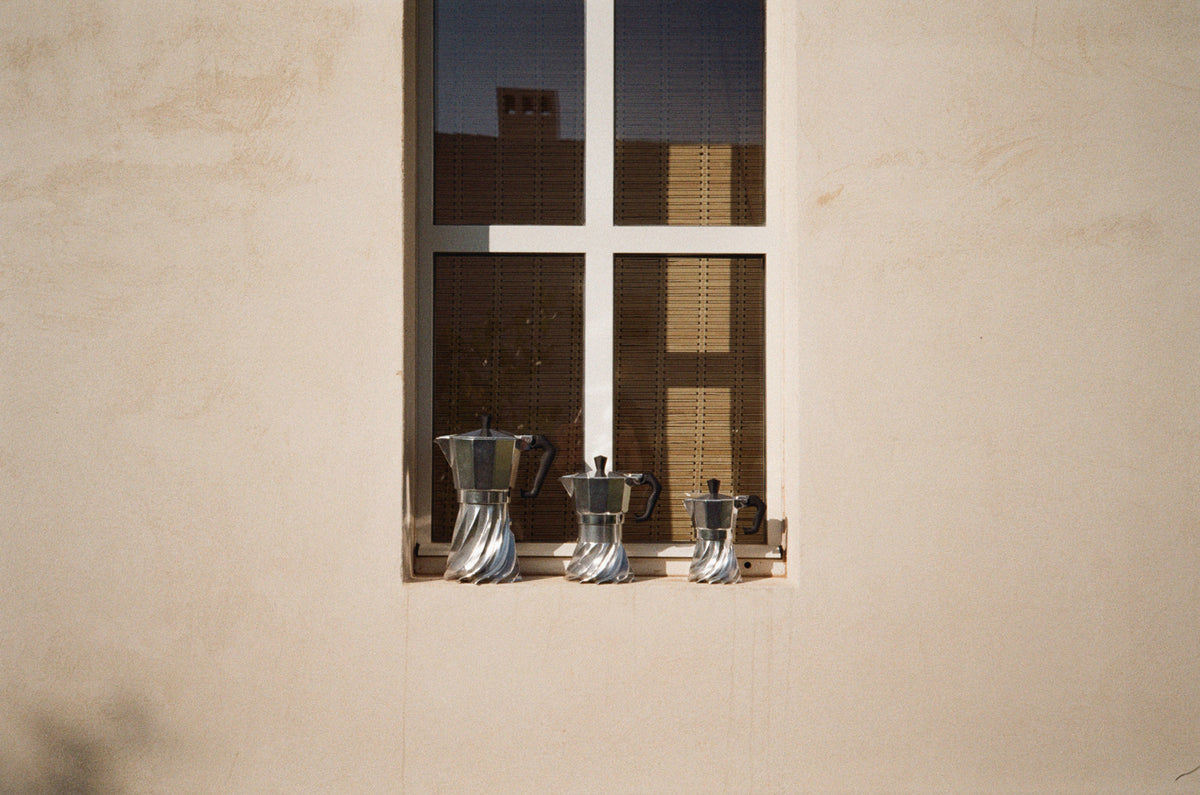Three sizes of Turbo Moka lined up on a sunlit windowsill, their turbine-finned bases catching the light