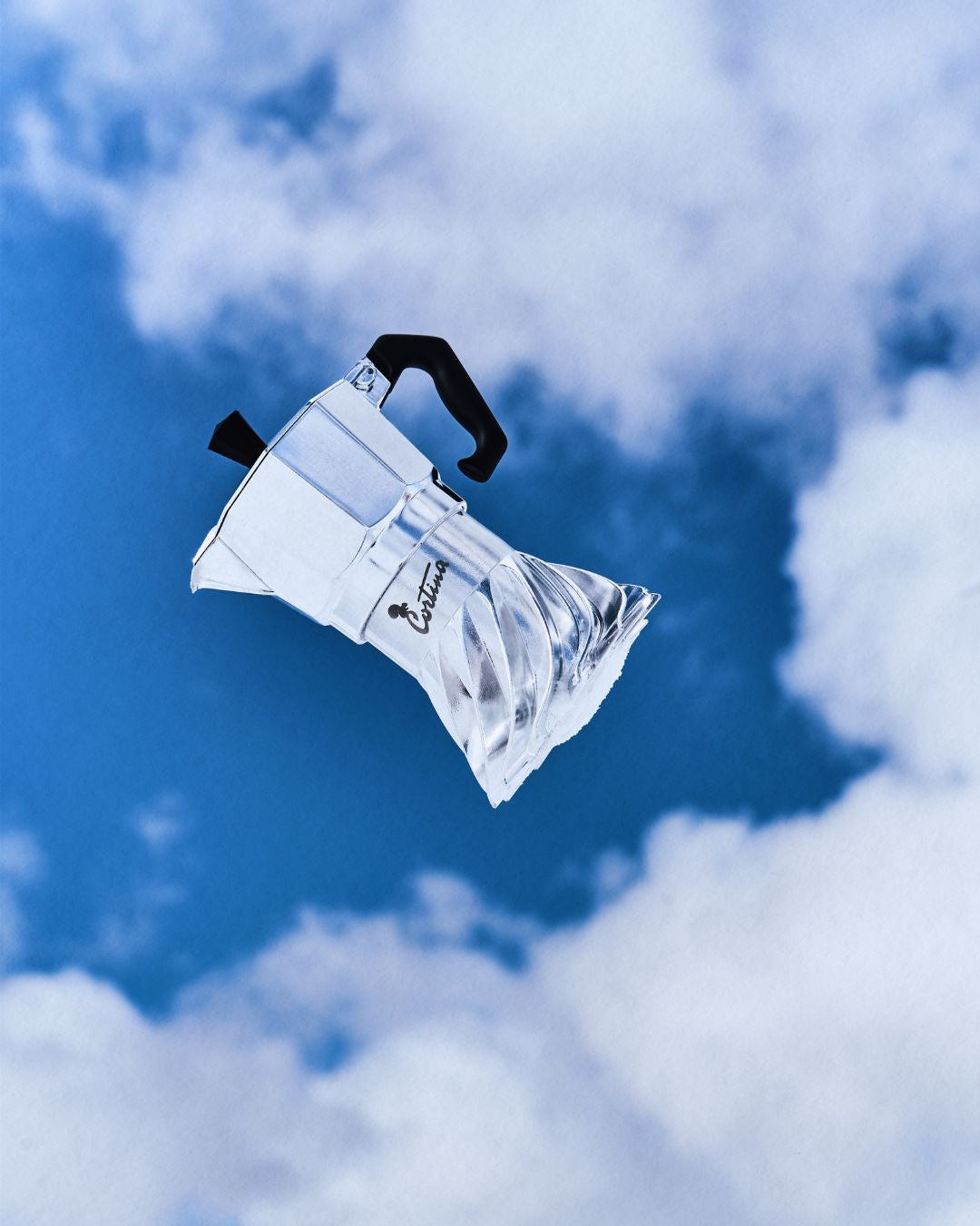 Turbo Moka Cortina d'Ampezzo Edition photographed against a blue sky with white clouds, Cortina engraving on the collar