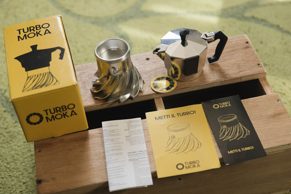 Turbo Moka Cortina Edition unboxed on a wooden board with its yellow gift box and instruction cards