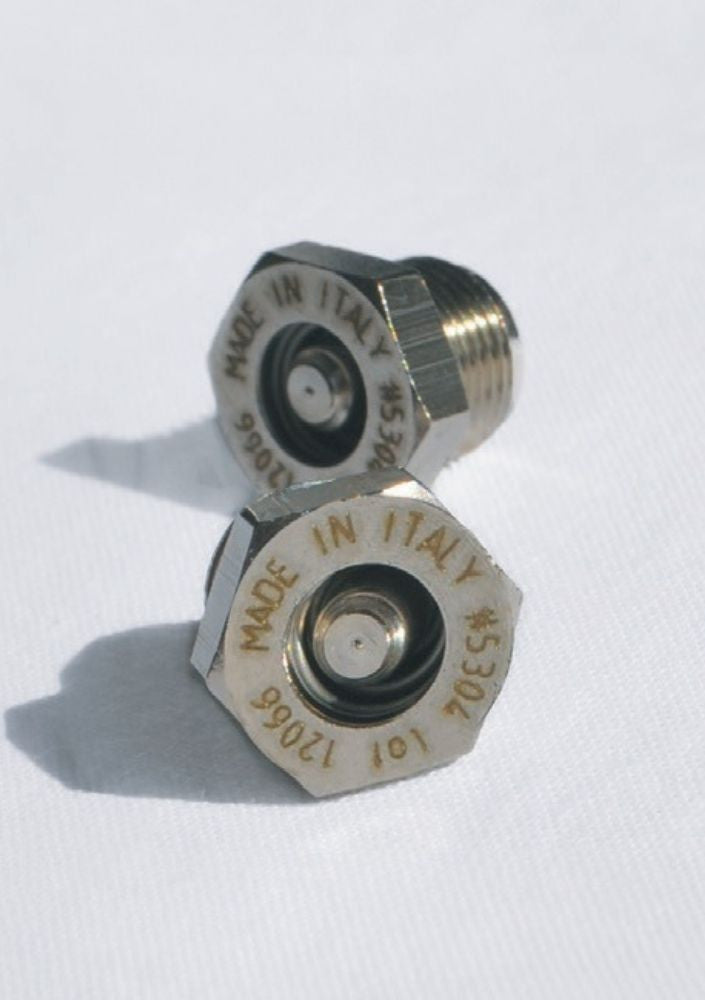 Two Turbo Moka safety valves on white cloth, each stamped Made in Italy with its part and lot number