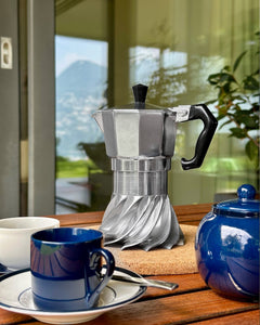 Turbo Moka on an outdoor breakfast table with blue ceramic cups and a mountain view behind