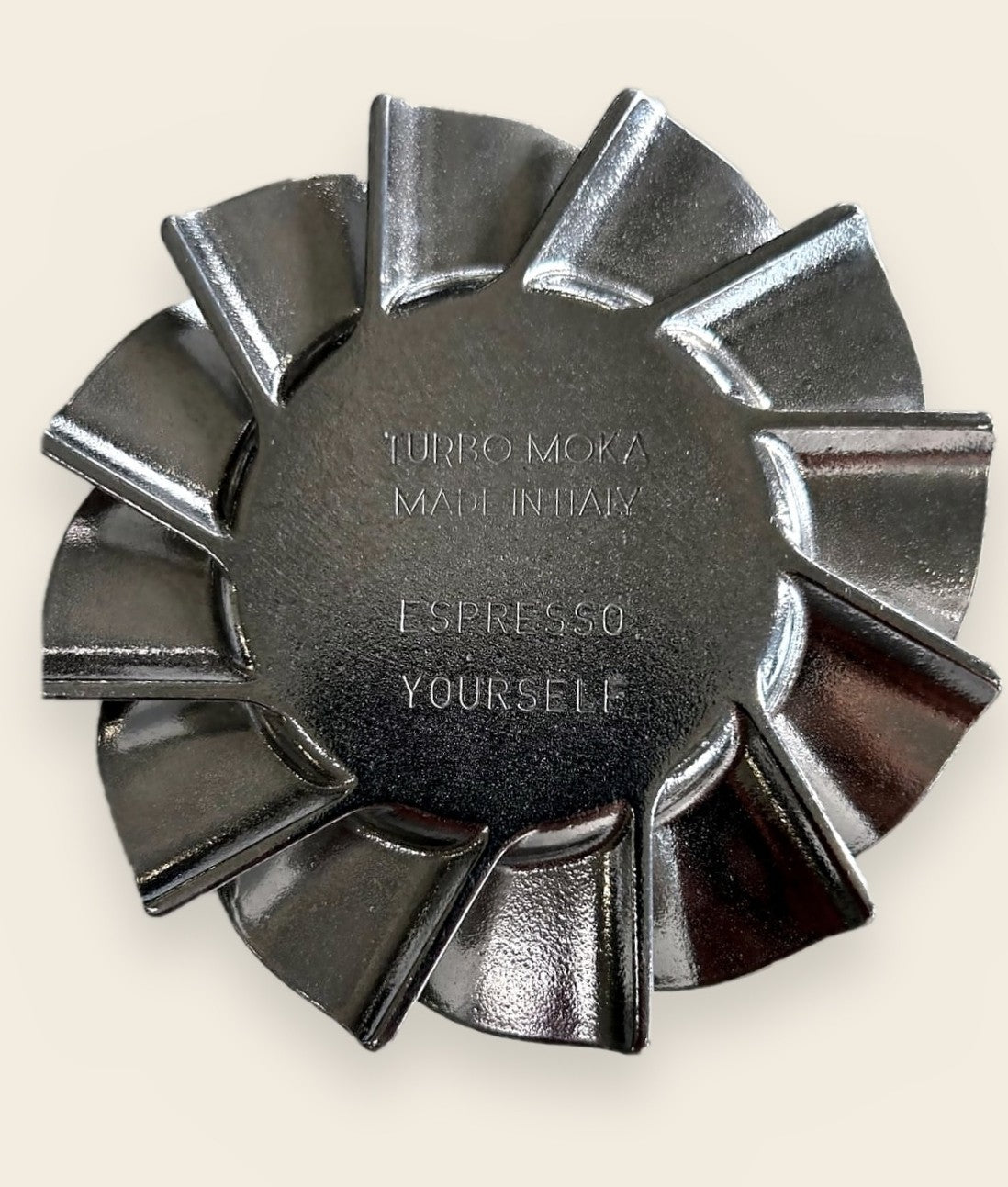 Underside of a Turbo Moka turbine base punch-engraved Espresso Yourself beneath Turbo Moka Made in Italy