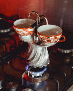 Turbo Moka Duetto on a lit gas flame filling two porcelain cups at once